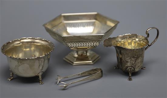 A George V silver cream jug and matching sugar bowl, a pierced silver hexagonal bowl and pair of silver sugar tongs.